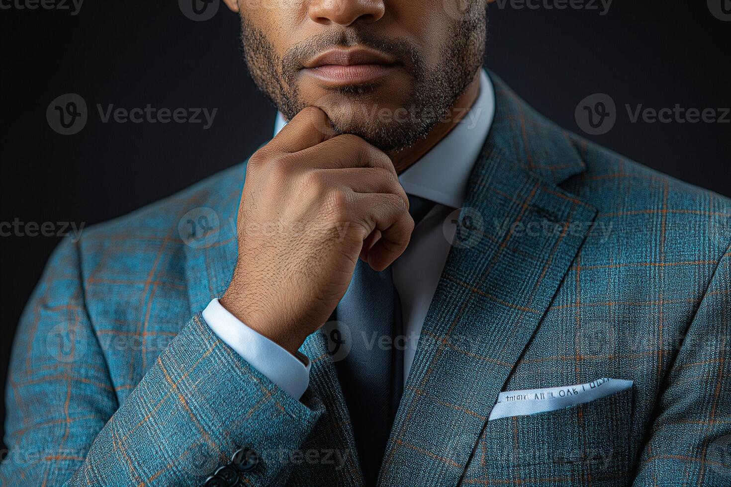 Stylish Black man in a suit thoughtfully resting his chin on his hand, creating an air of confidence and elegance. photo