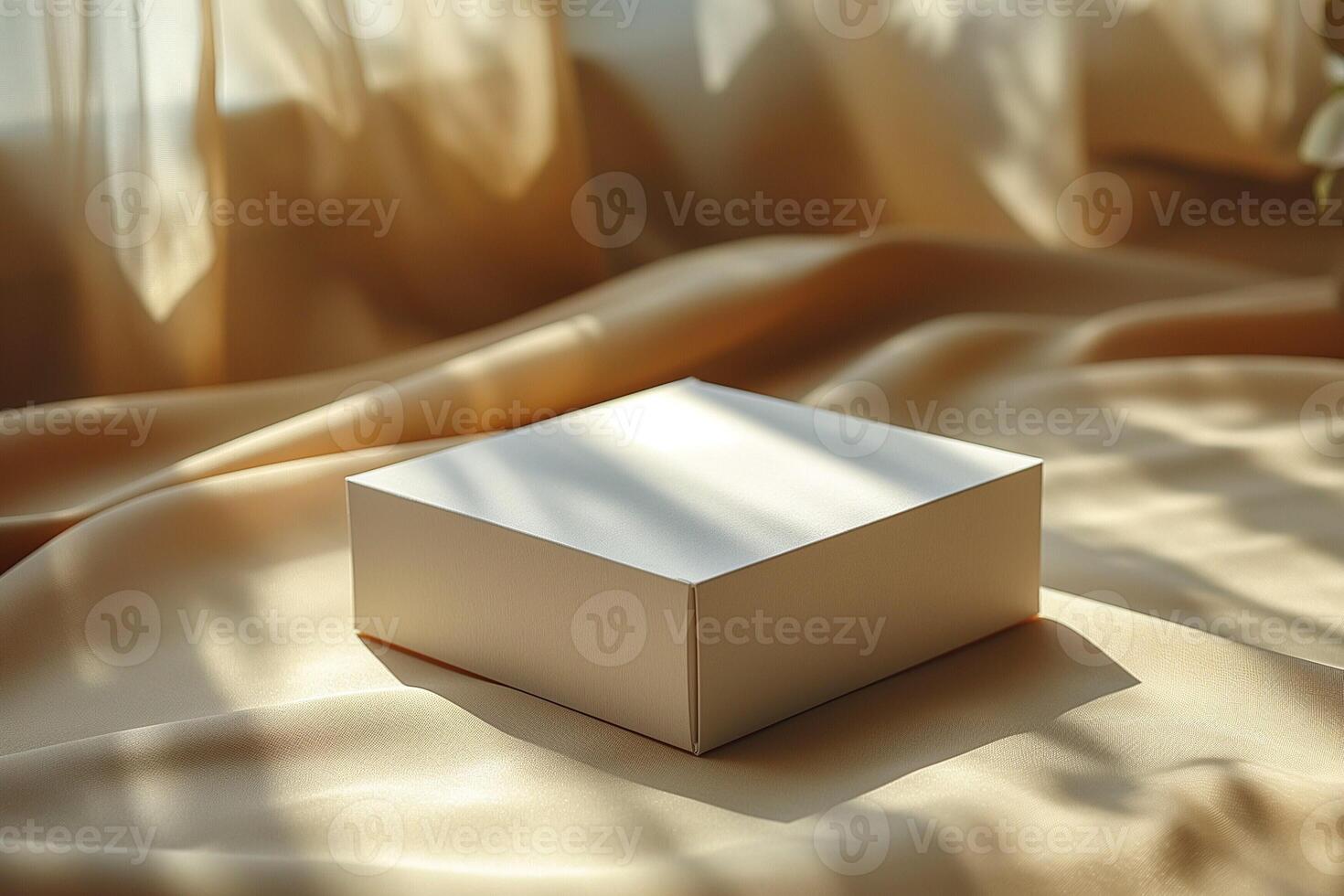 A simplistic, elegant white box rests on a soft, golden fabric, illuminated by gentle sunlight filtering through sheer curtains. photo