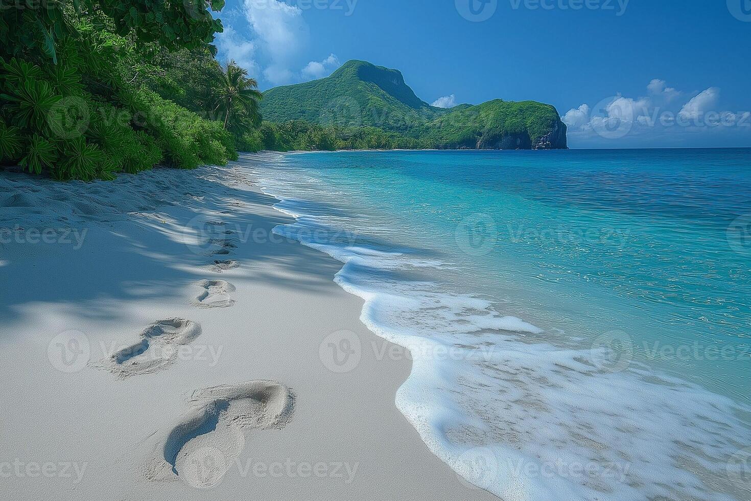 Serene beach with footprints leading into the turquoise water and lush green mountains in the background. photo