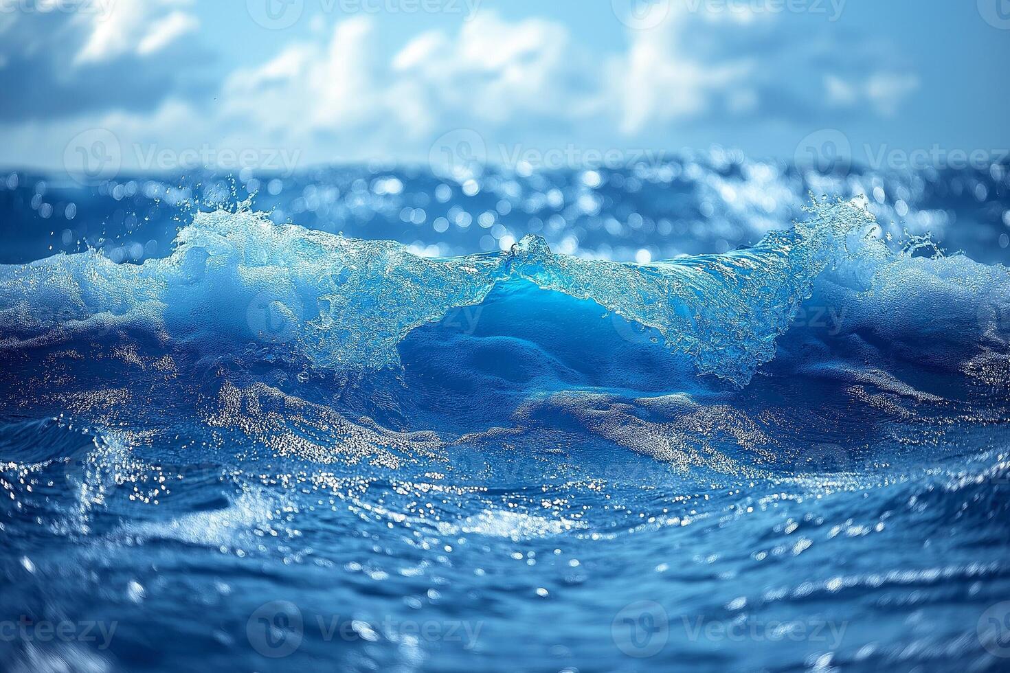 A dynamic blue ocean wave captures the sunlight, creating a sparkling spectacle under a bright sky. photo