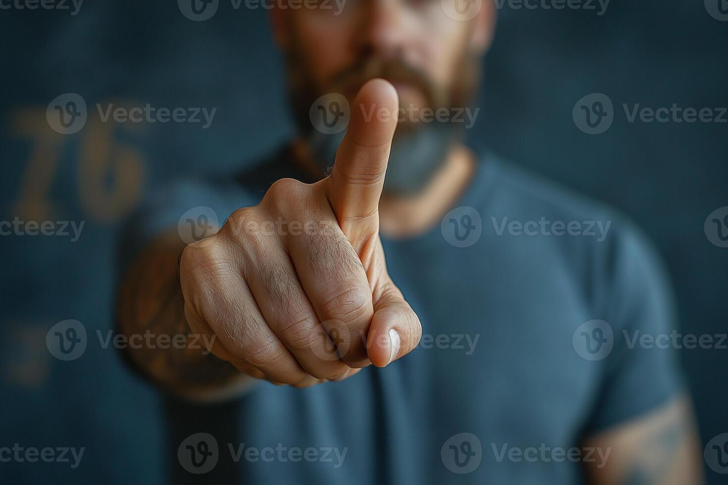 A focused man with a beard gestures with one finger raised, conveying significance and determination. photo