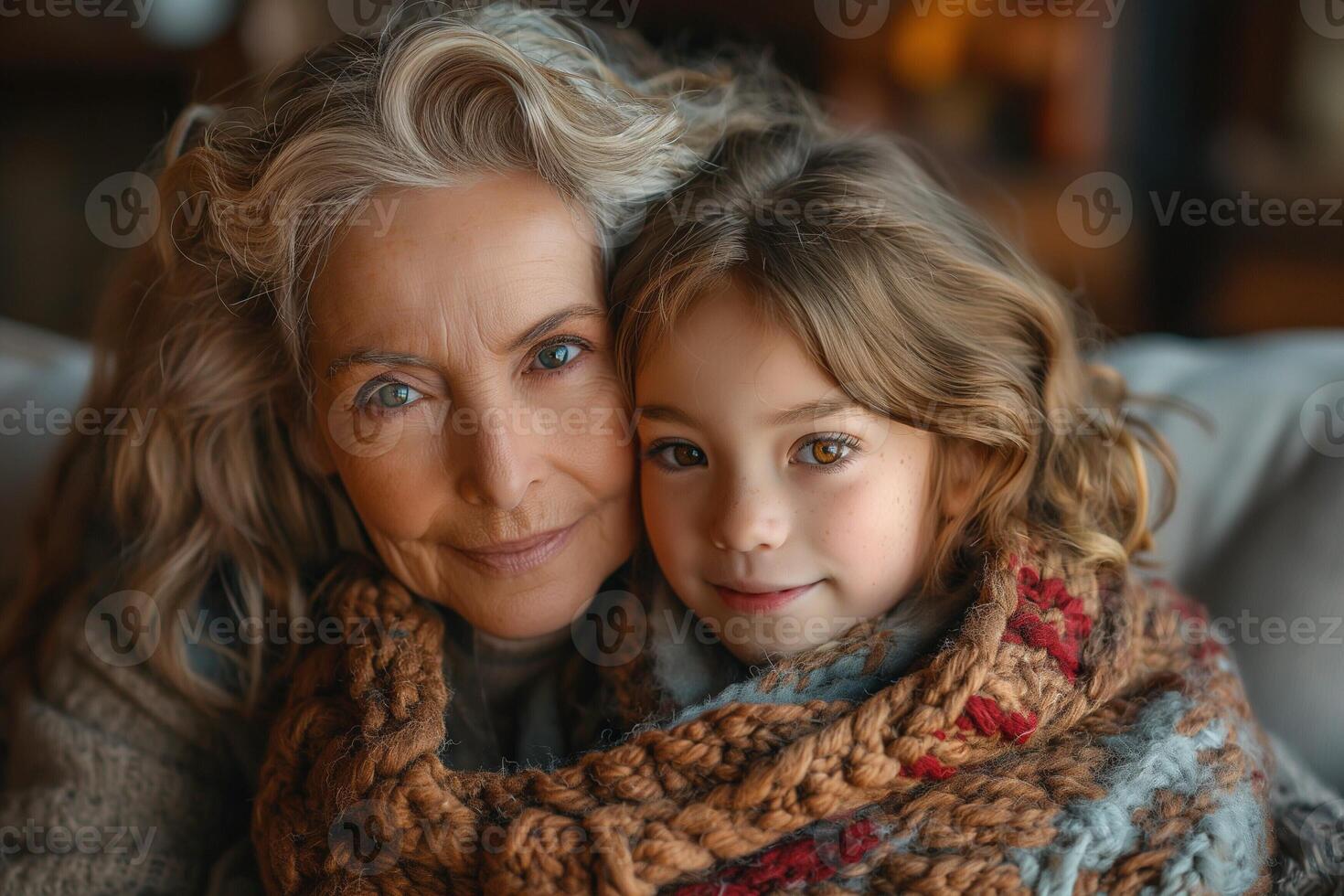 A warm embrace between a Caucasian elderly woman and a young girl, both wrapped in cozy, colorful blankets. photo