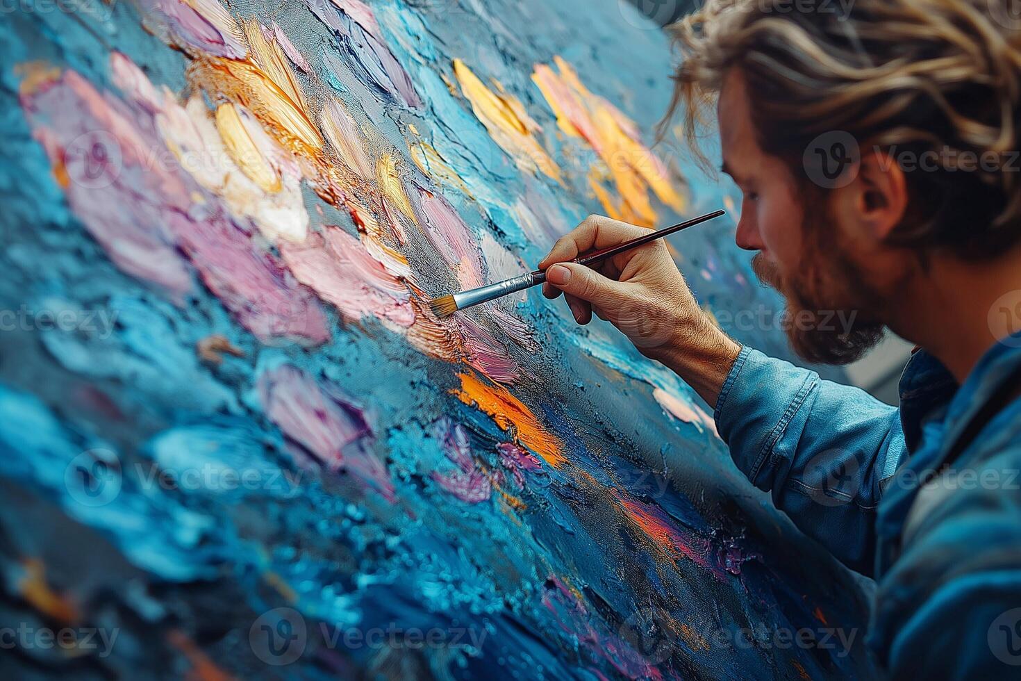 A focused young Caucasian man passionately painting an abstract artwork with vibrant colors and textures. photo