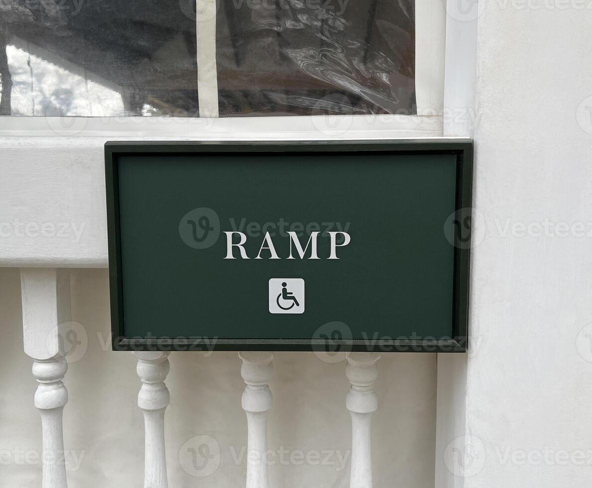 Close up of a ramp sign for a wheelchair and handicapped accessible entrance sign photo