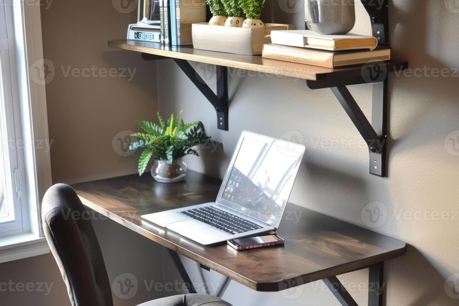 home office with a minimalist dark wood desk, a laptop, a phone, a potted plant, and shelves photo