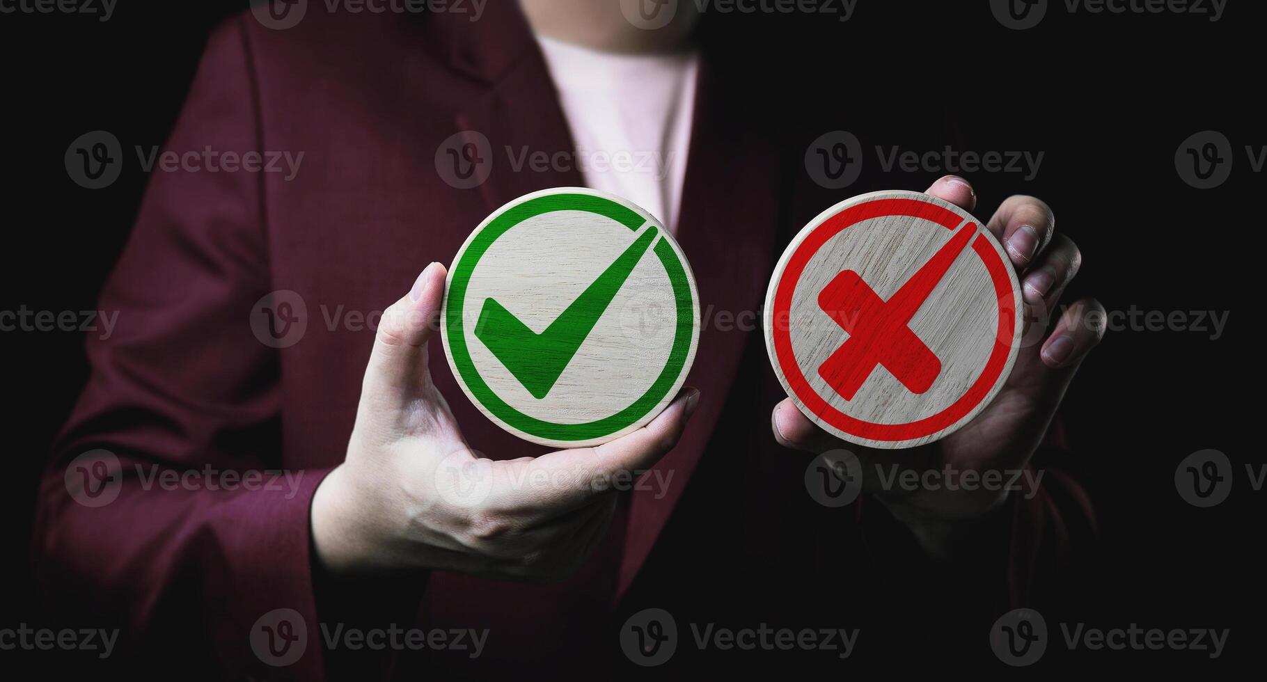 Businessman holds a circle of wood with green check mark and red cross icon. Right and wrong concept. checklists, approval lists, and test. photo
