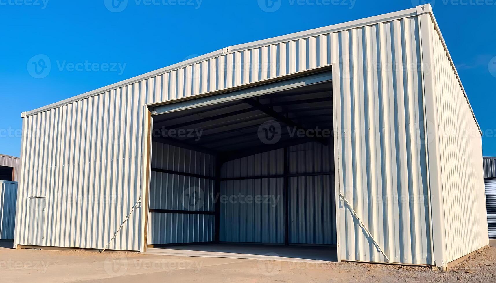 Metal Storage Shed with Open Garage Door and Clear Blue Sky Background Ideal for Warehouse or Container Storage Solutions photo