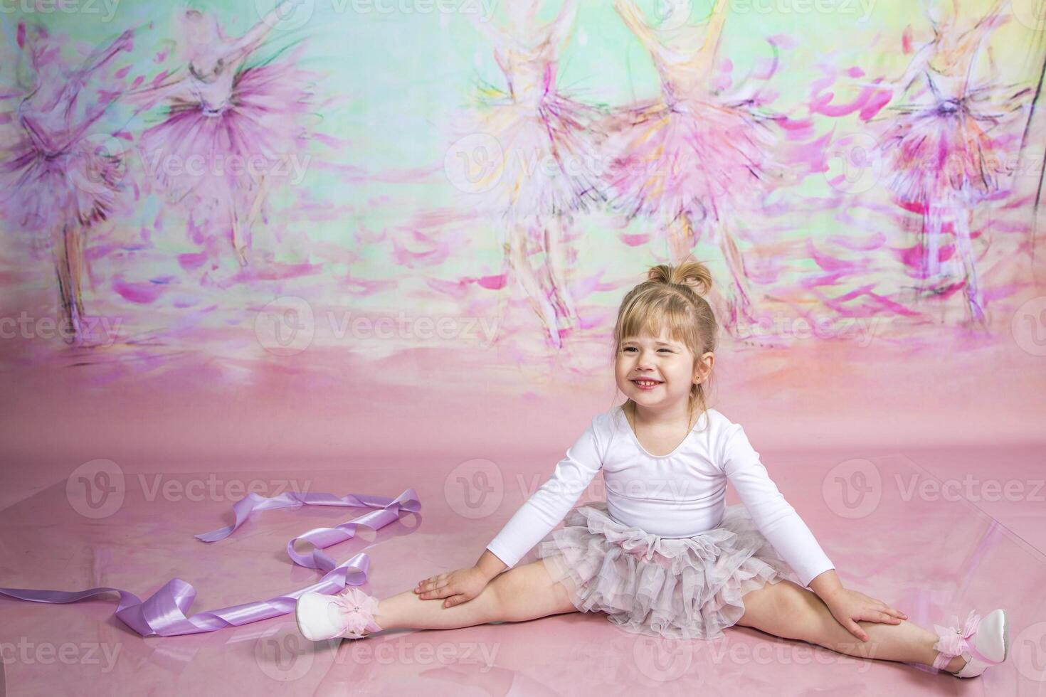 A little girl sitting on the floor with her legs crossed photo