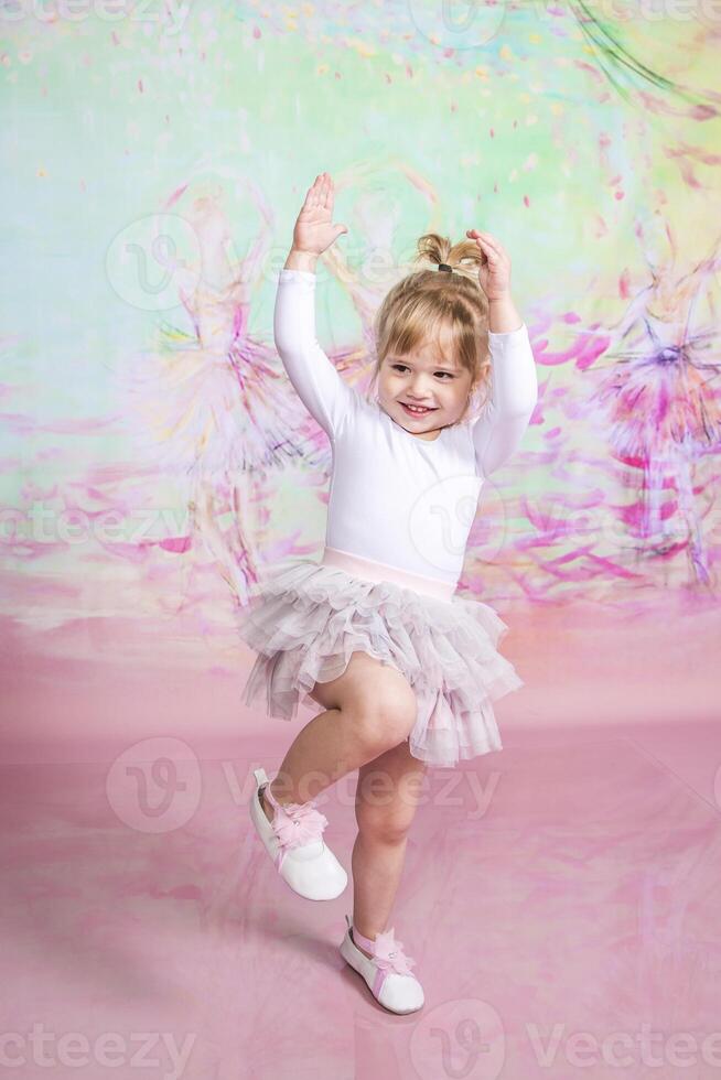 A little girl in a tutu and white shoes is dancing photo