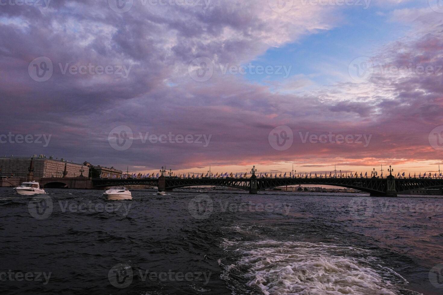 A boat is traveling on the water during a sunset photo