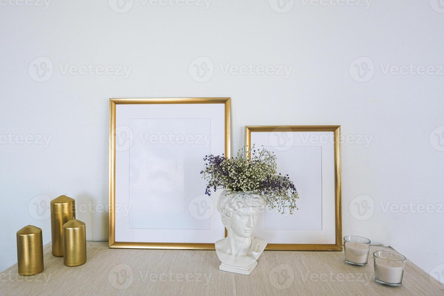 Gold frames on a table with flowers and candles photo