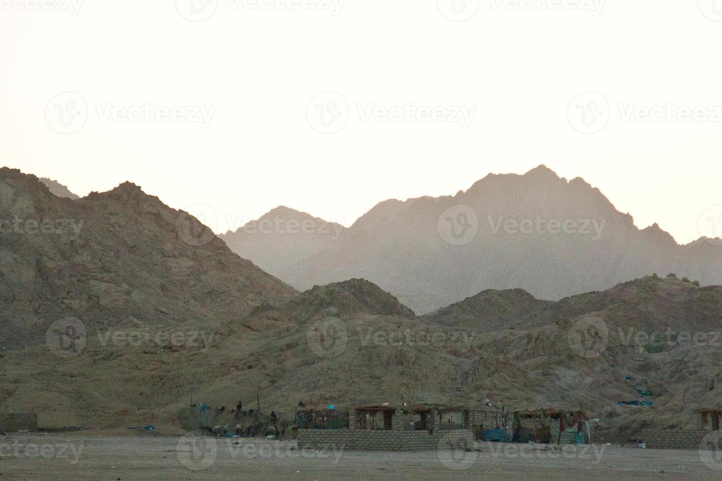 A desert area with mountains in the background photo