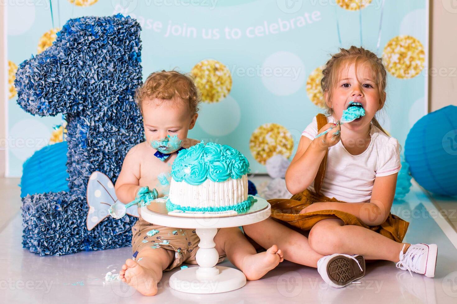 boy playing with a cake during cake smash birthday party photo