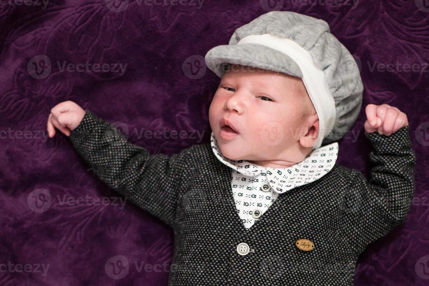 A baby wearing a hat and a suit photo