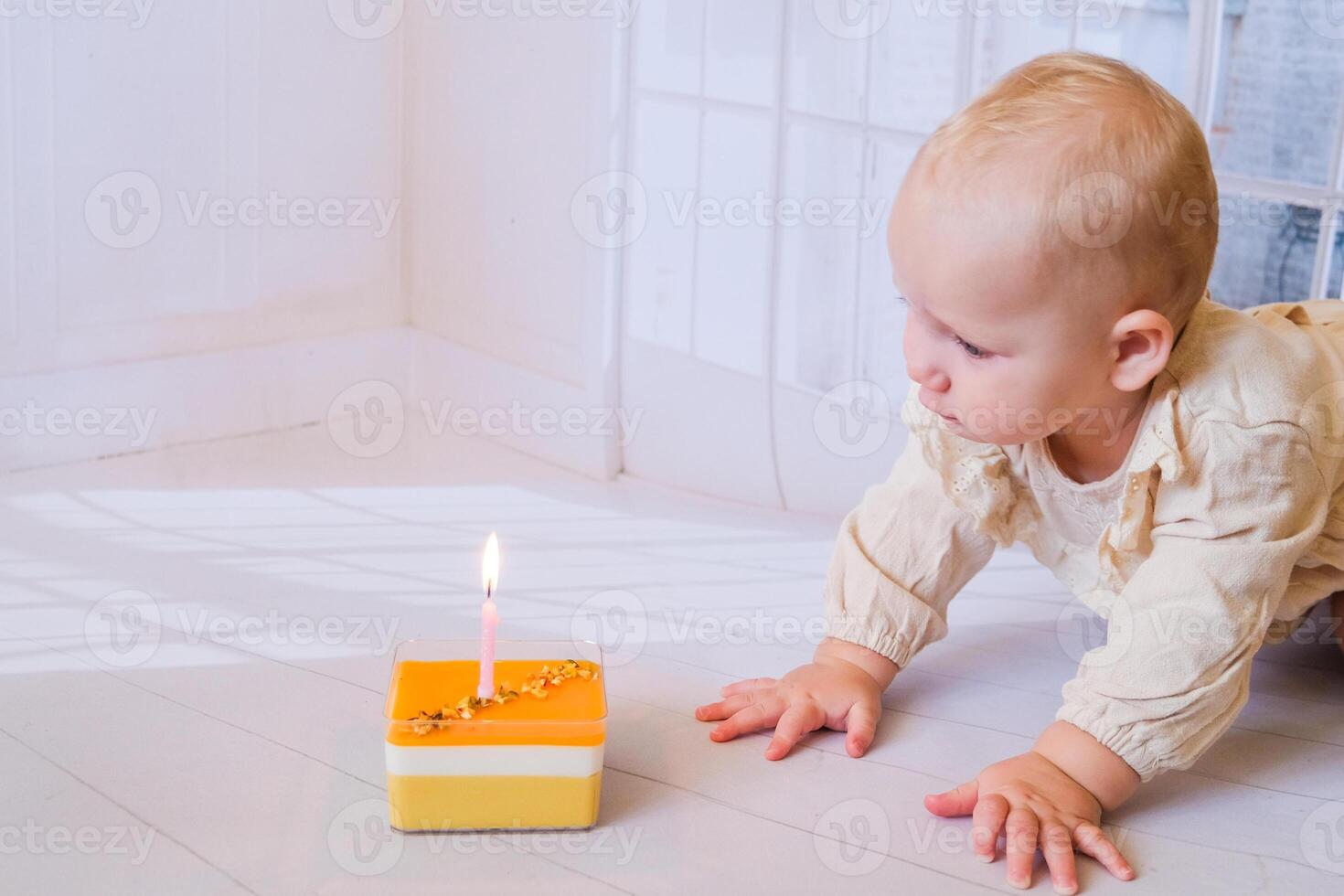 A baby crawling on the floor with a lit candle photo
