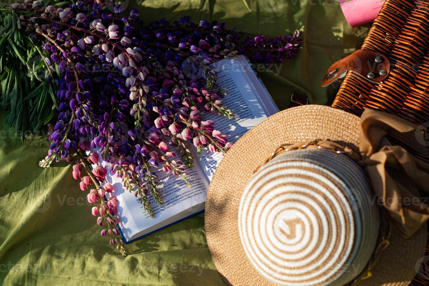 A hat, a book, and a basket of flowers photo