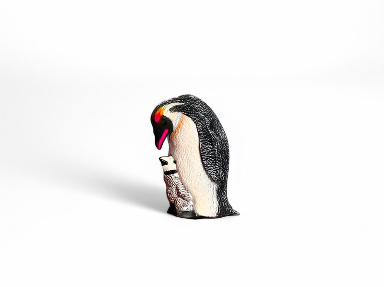A penguin and a baby penguin are standing next to each other photo