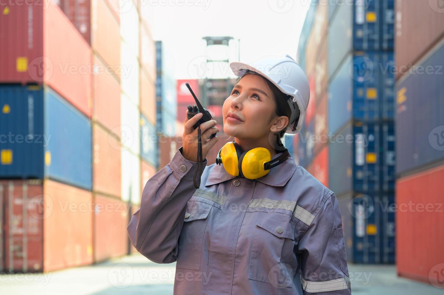 Industrial Asian female engineer checking containers using walkie talkie in front of container cargo freight ship for container loading photo