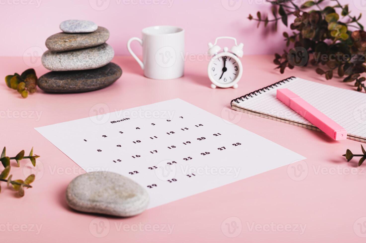 Monthly calendar and blank planning notebook on the desktop photo