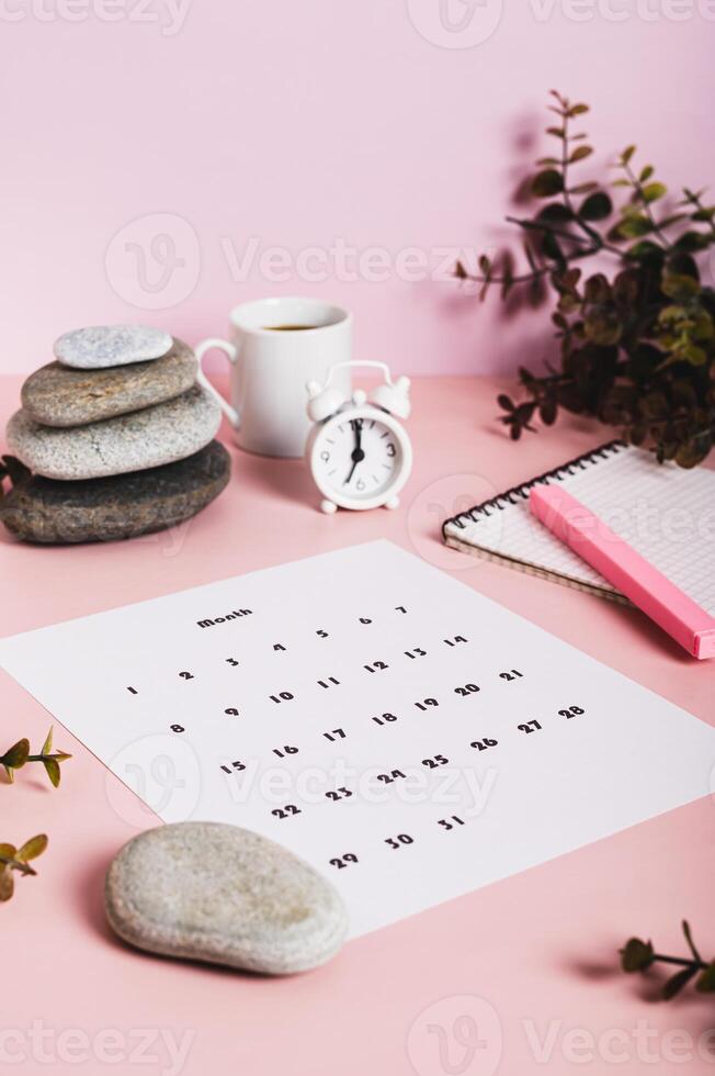 Monthly calendar and blank planning notebook on the desktop vertical view photo