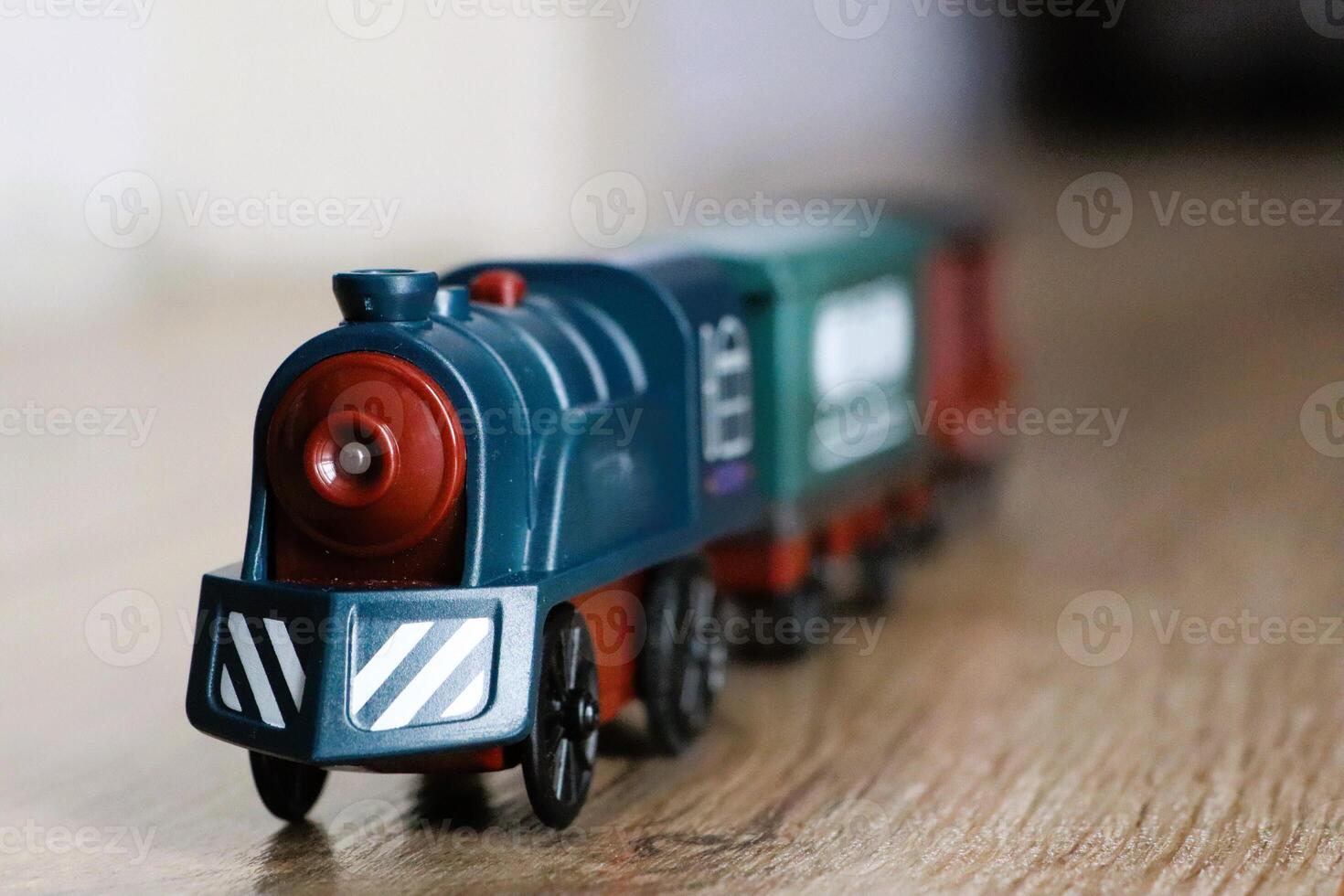 A Colorful Toy Train Positioned on a Beautiful Wooden Surface, Ready for Adventure photo