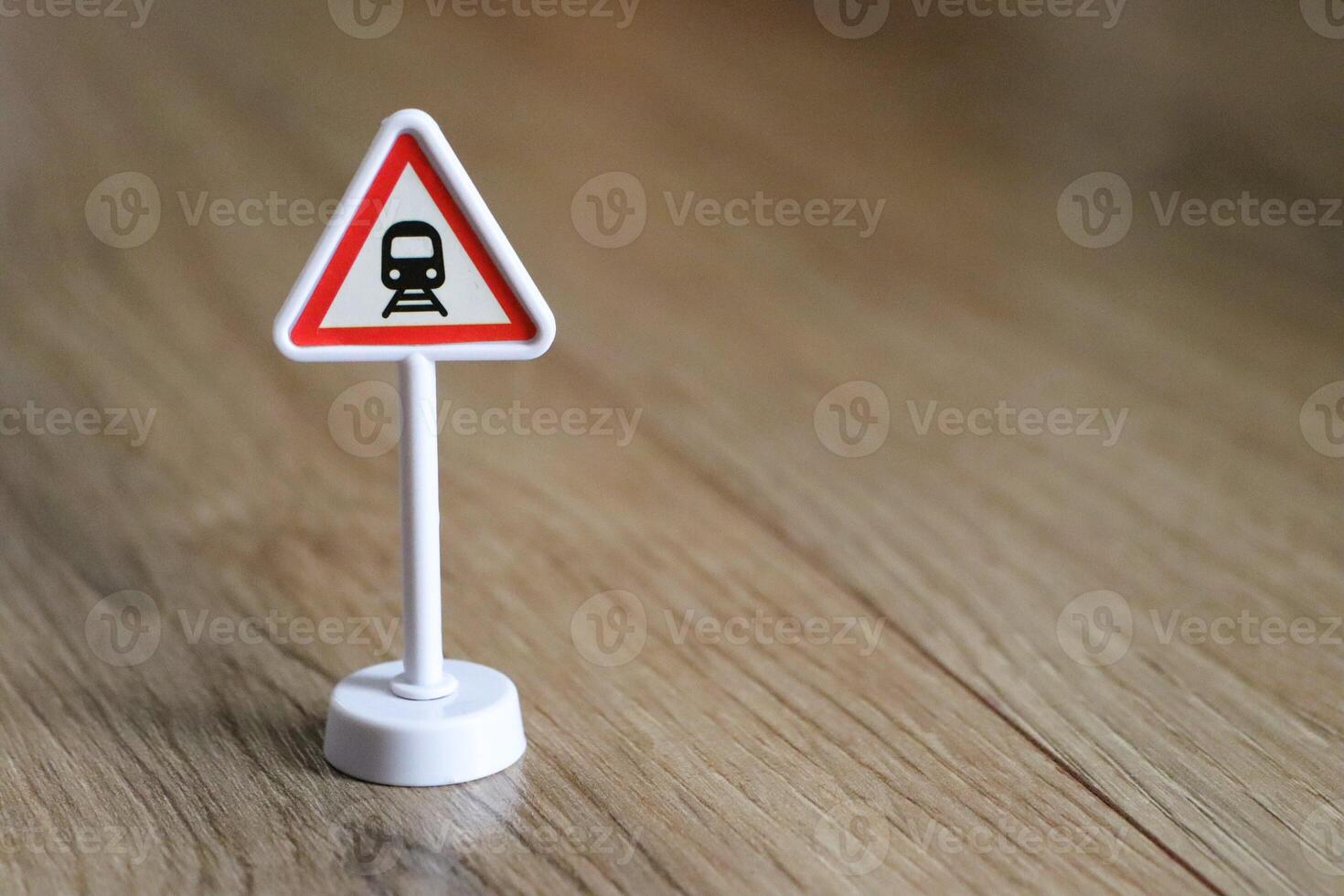 Warning Sign for Train Crossing placed on wooden floor for visibility and caution photo