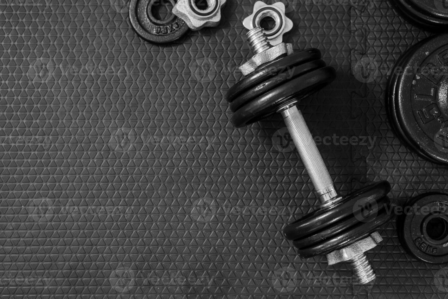 Top view of Iron dumbbells or weights on black floor with copy space for text photo