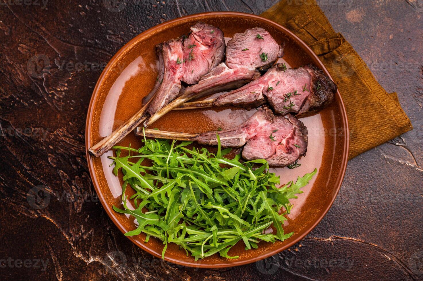 Roasted lamb chop cutlets, mutton meat steaks with salad. brown background. top view photo