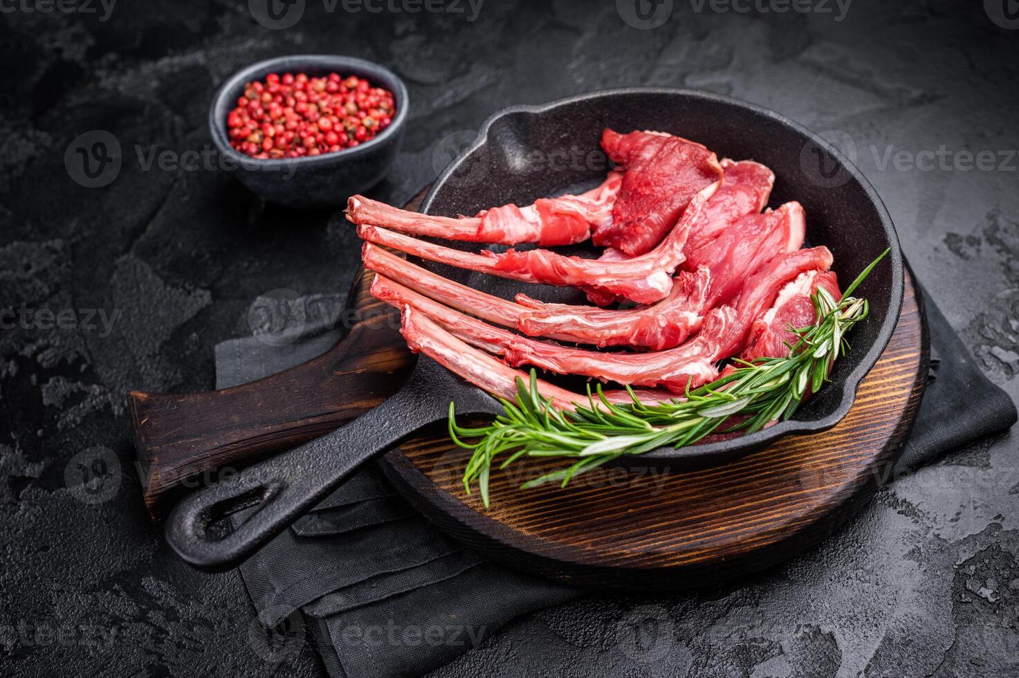 Ready for cooking Raw lamb meat chops, fresh mutton cutlets in a pan. black background. top view photo