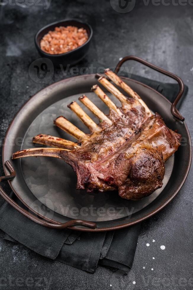 Roast Rack of lamb chops, mutton organic meat. black background. top view photo