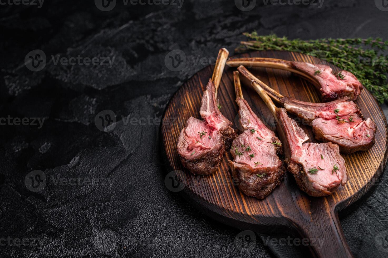French roast lamb chops, mutton meat steaks on wooden board. black background. top view photo