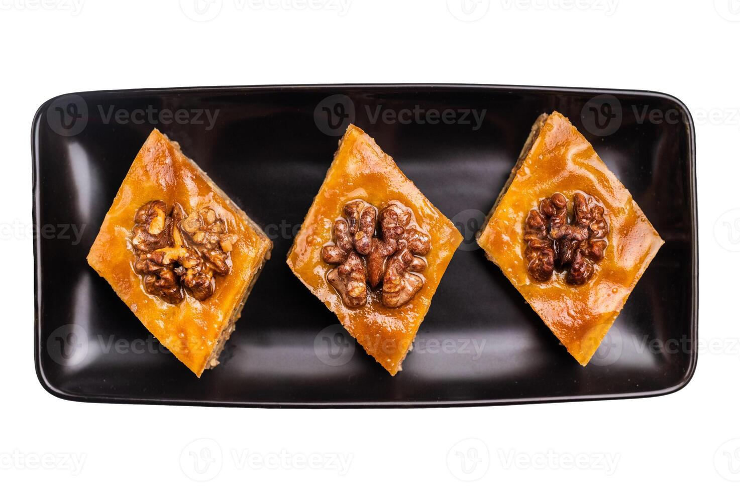 Homemade Walnut Baklava with honey on plate isolated on white background. top view photo