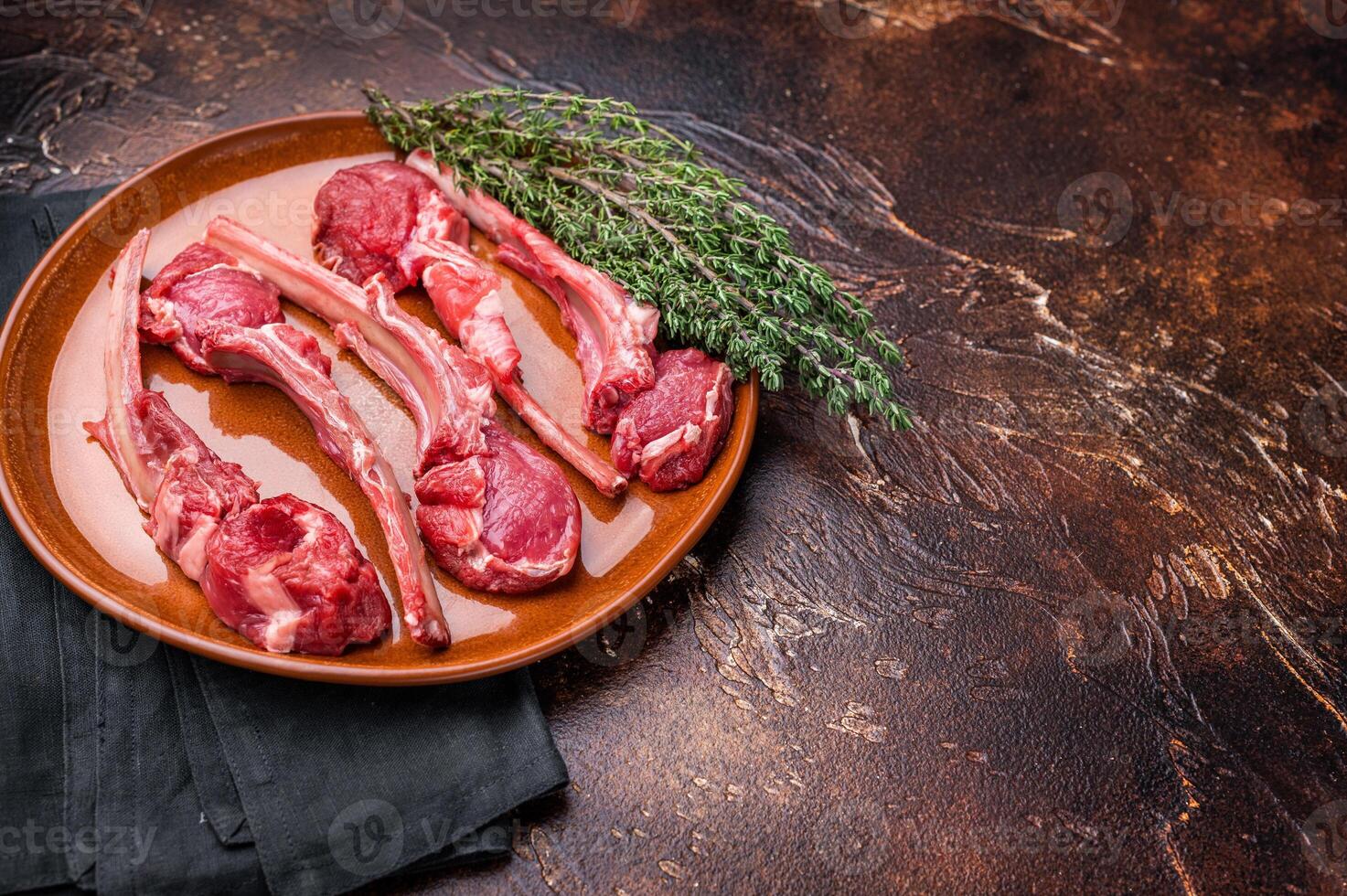 Uncooked lamb chops, fresh mutton meat steaks on a plate. brown background. top view photo