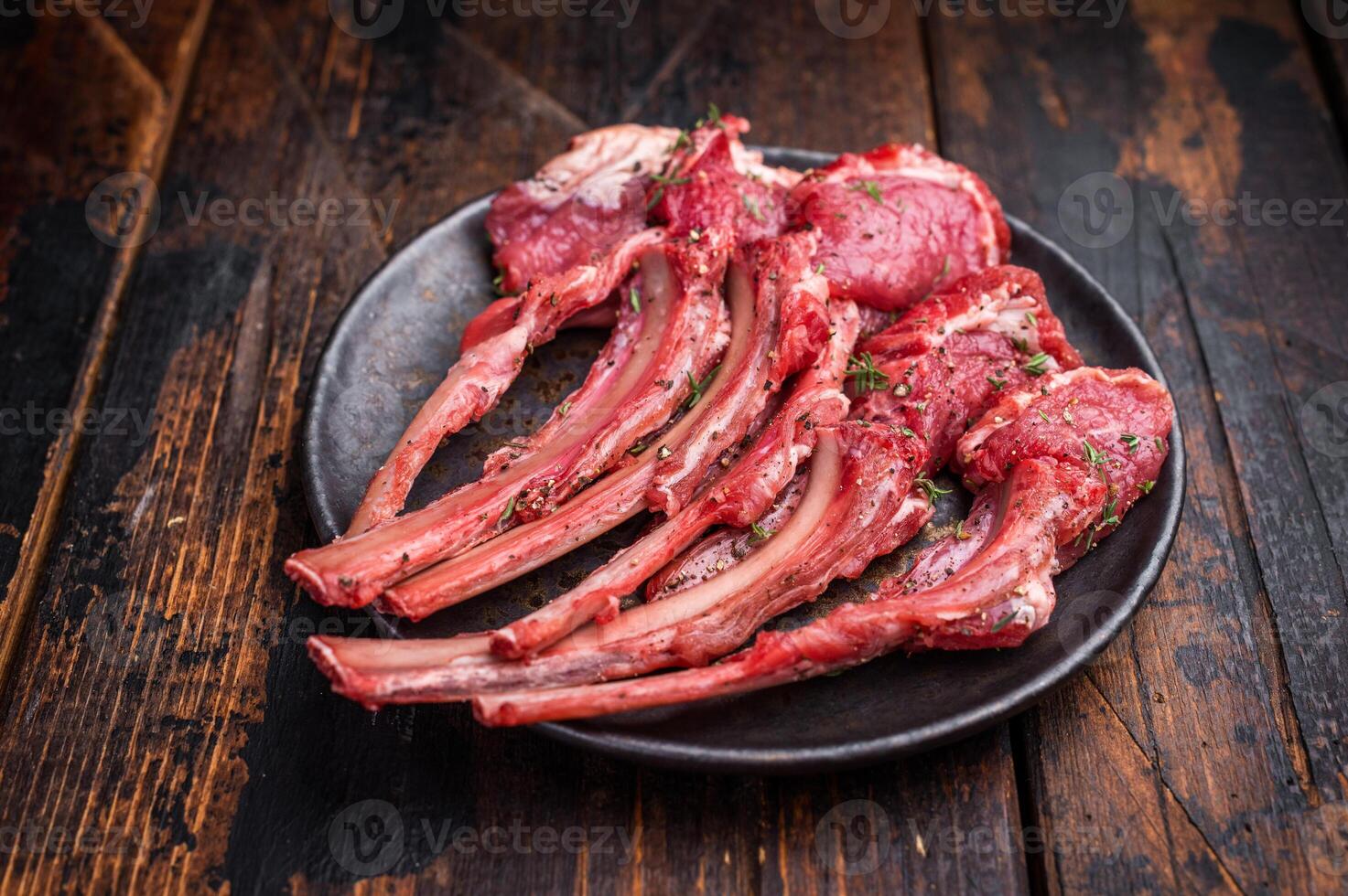 Raw lamb chop cutlets fresh mutton meat for steaks with herbs. wooden background. top view photo