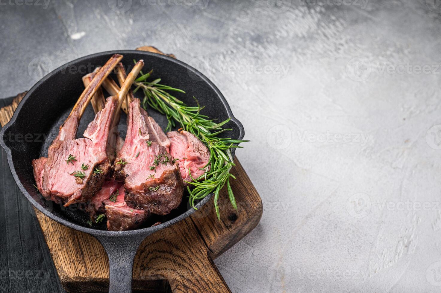 Roast lamb chops, mutton meat cutlets in a skillet. grey background. top view photo