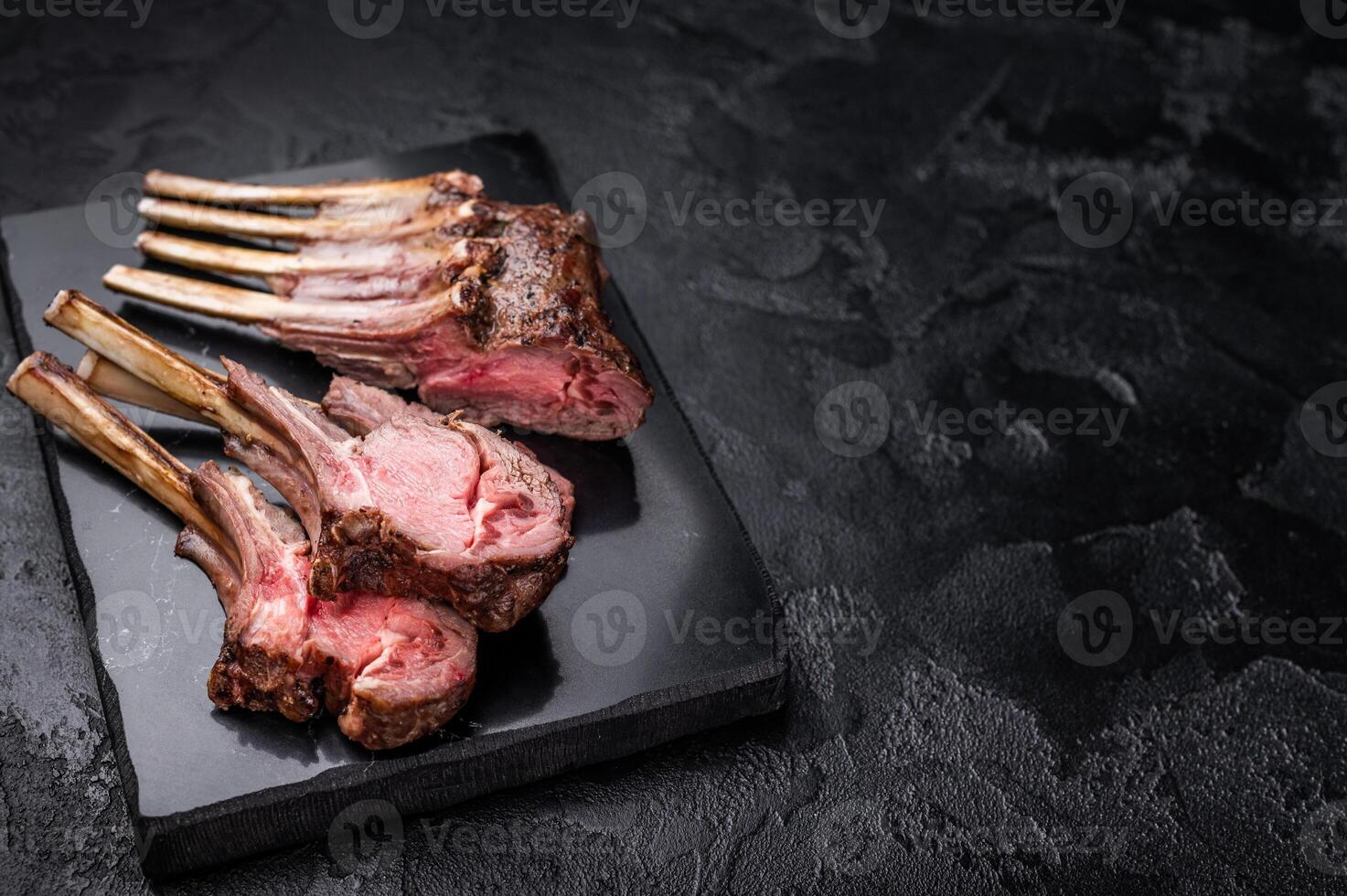 Roasted lamb chops steaks, mutton meat cutlets. black background. top view photo