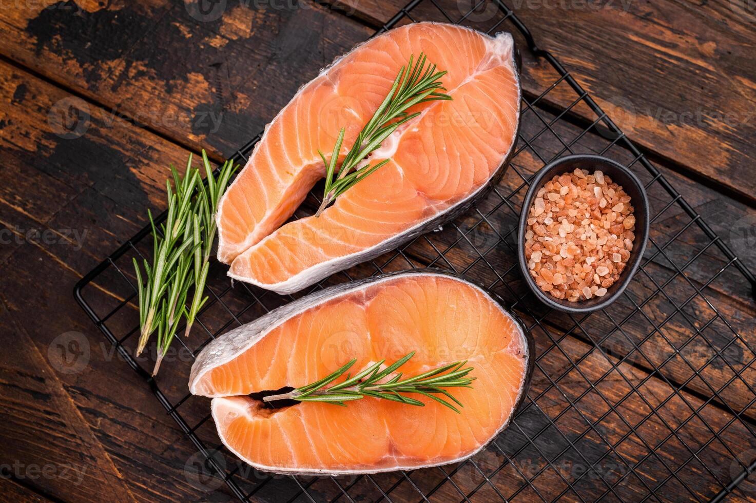 Vibrant raw salmon steak, showcasing its rich color and texture, ideal for sushi or sashimi enthusiasts seeking quality ingredients. wooden background. top view photo