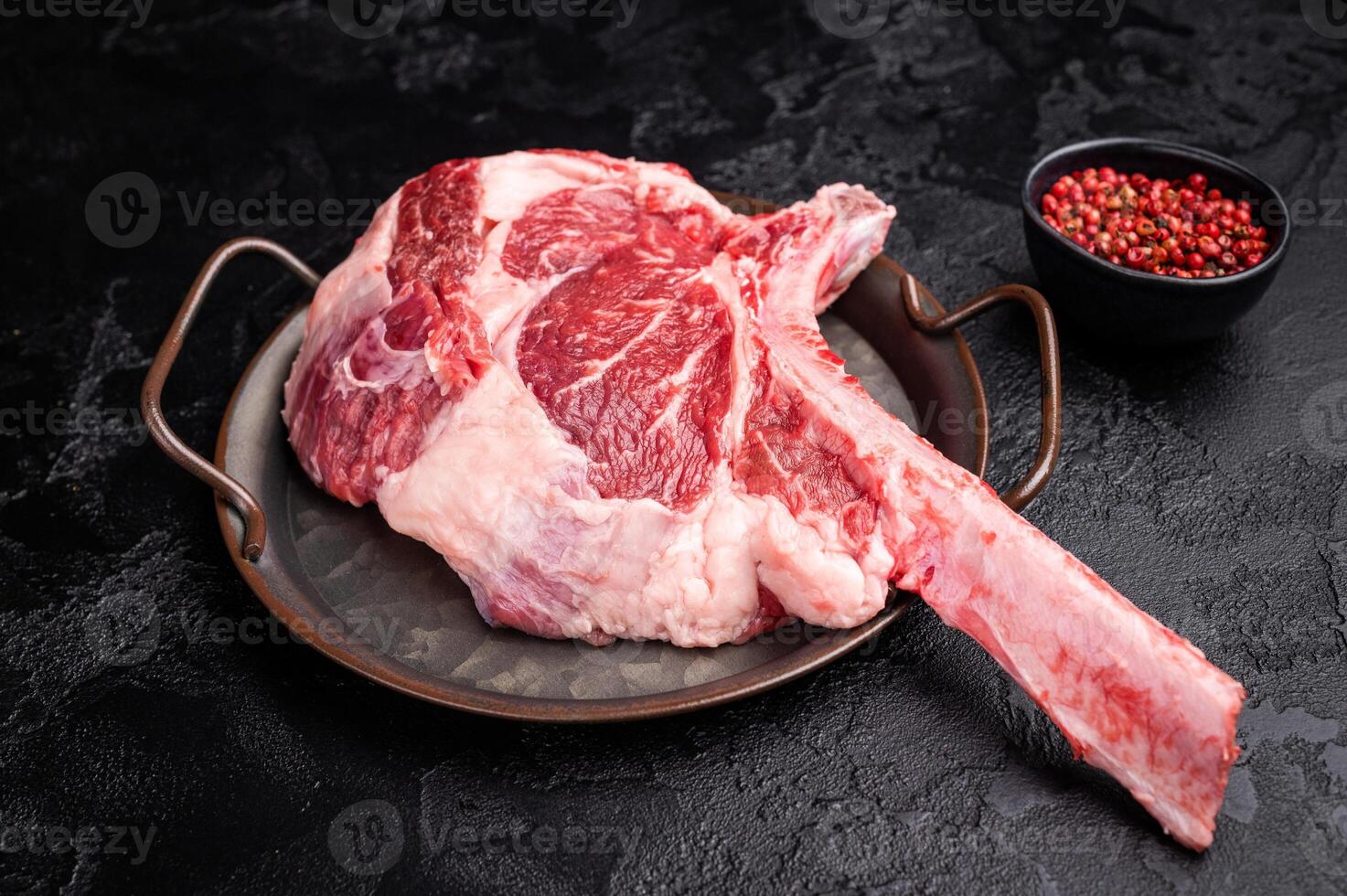 Raw tomahawk steak with marbling, fresh rib eye with bone. black background. top view photo