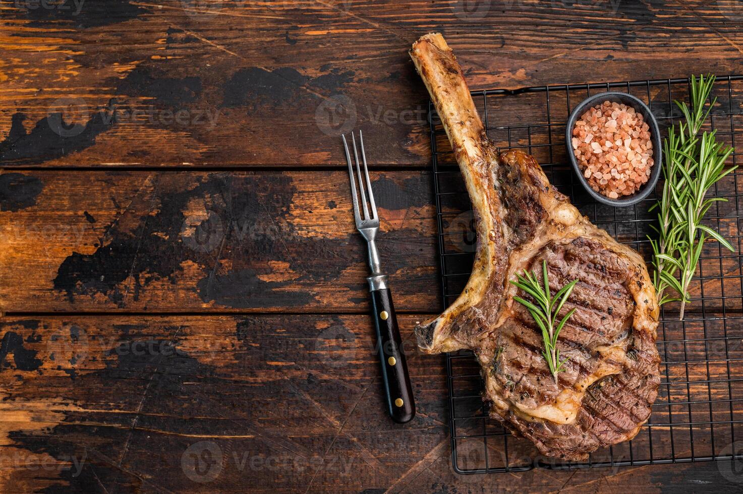 Grilled Tomahawk beef steak, cooked rib eye with bone. wooden background. top view photo