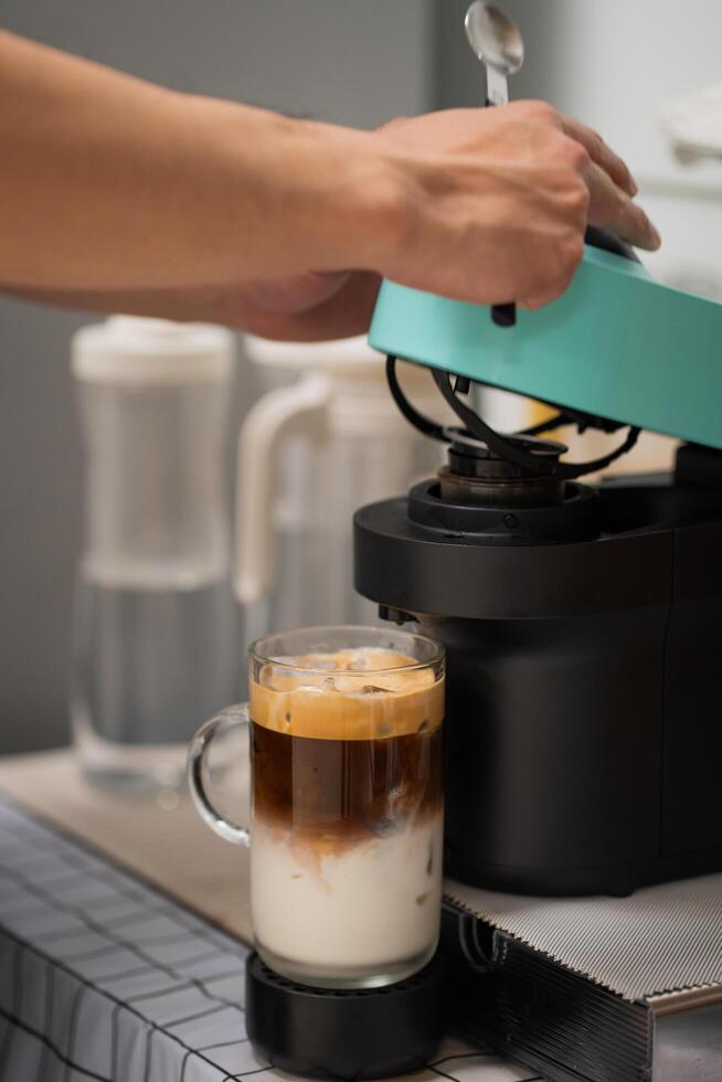 Man using capsule coffee machine with espresso cup. Nespresso is worldwide leader company with coffe machines and capsules. photo