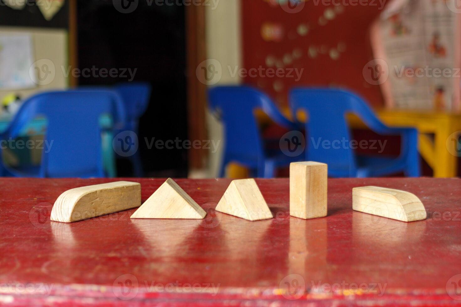 Geometric Wooden Blocks on a Red Table in a Classroom photo