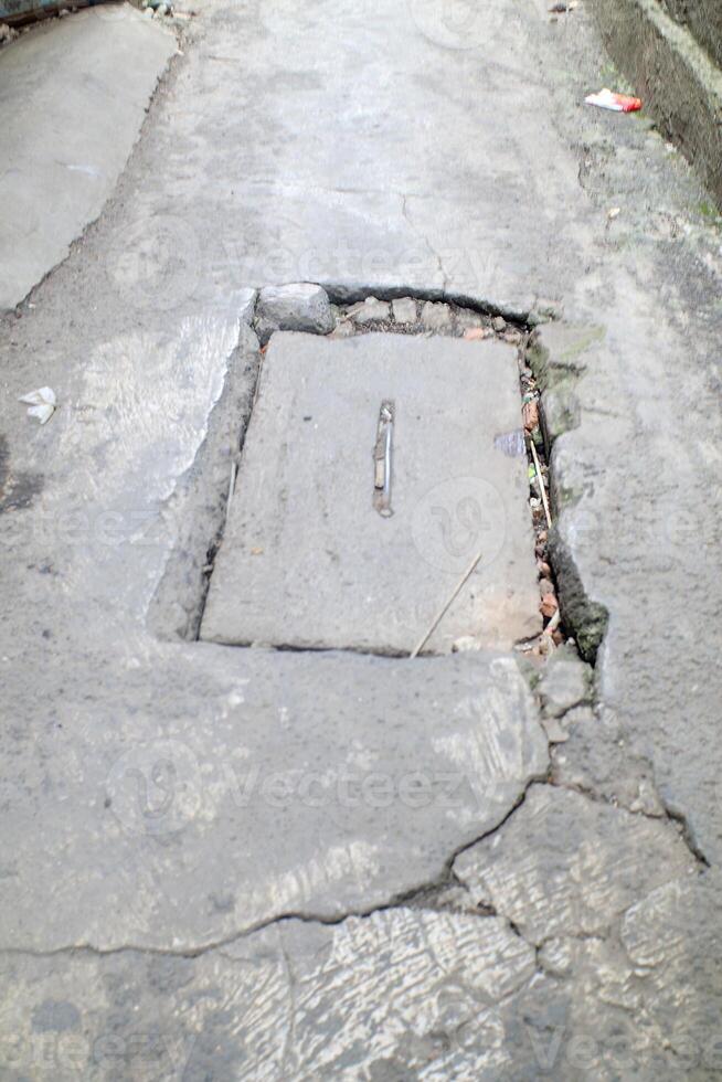 Urban Street with Broken Concrete and Drain photo