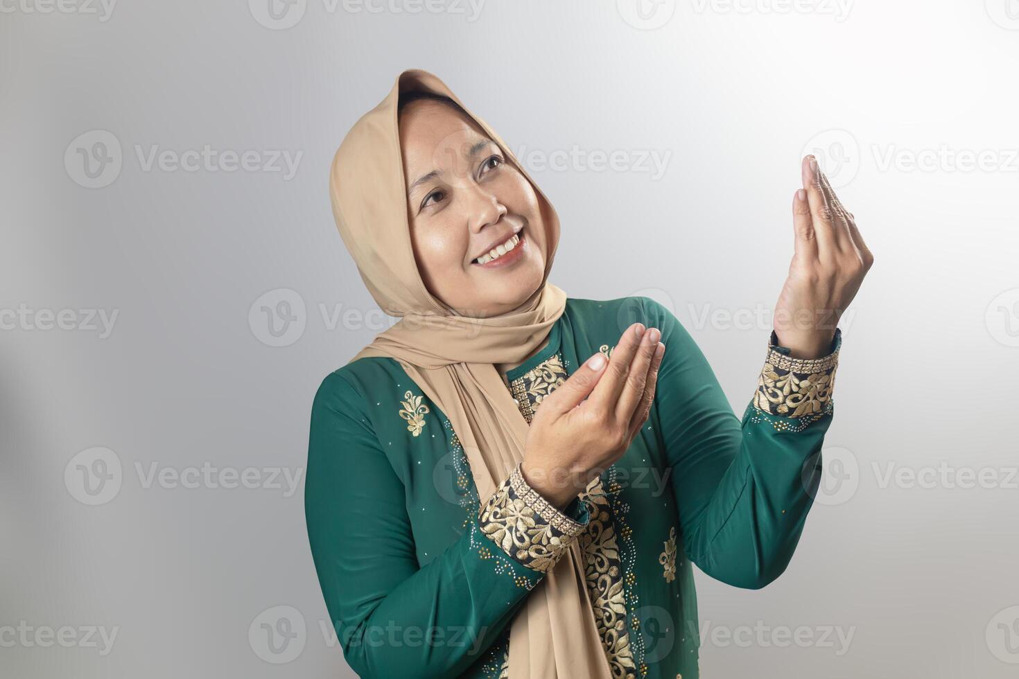 Smiling Woman in Traditional Green Dress Gesturing with Hands photo