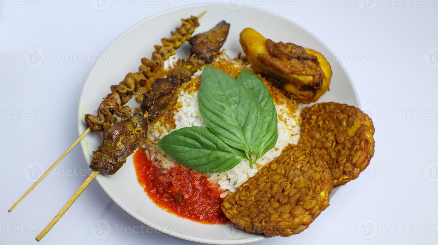 Indonesian Traditional Nasi Uduk with Tempeh, Satay, and Sambal photo