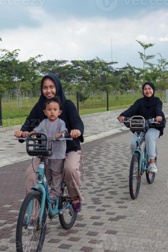 Muslim Sisters Enjoying a Bicycle Ride in the Park photo