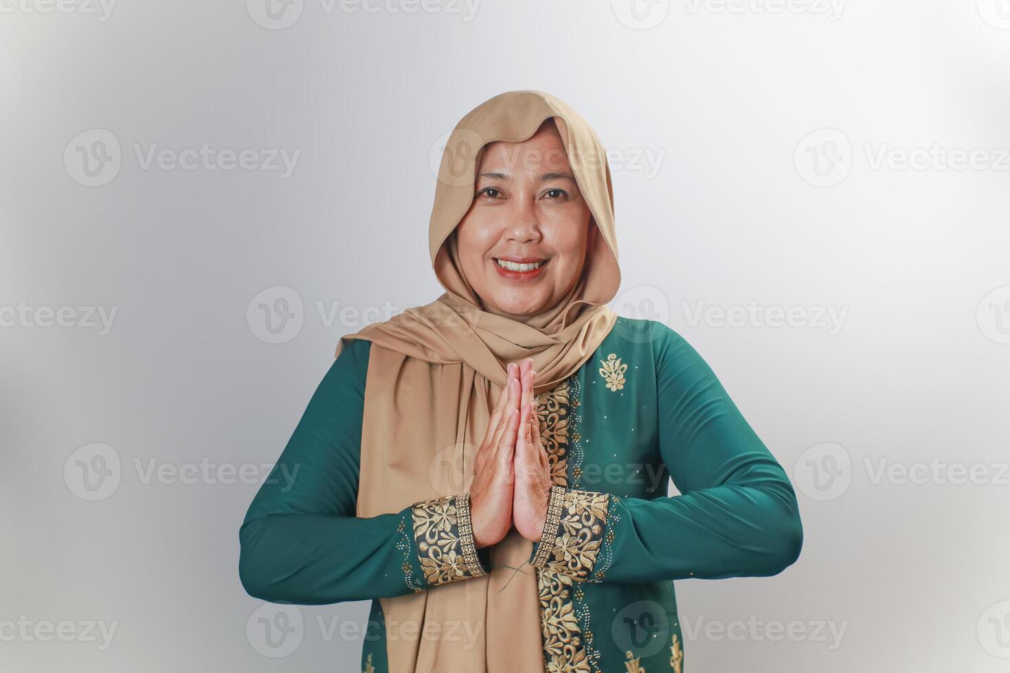 Smiling Woman in Traditional Green Dress with Greeting Pose photo