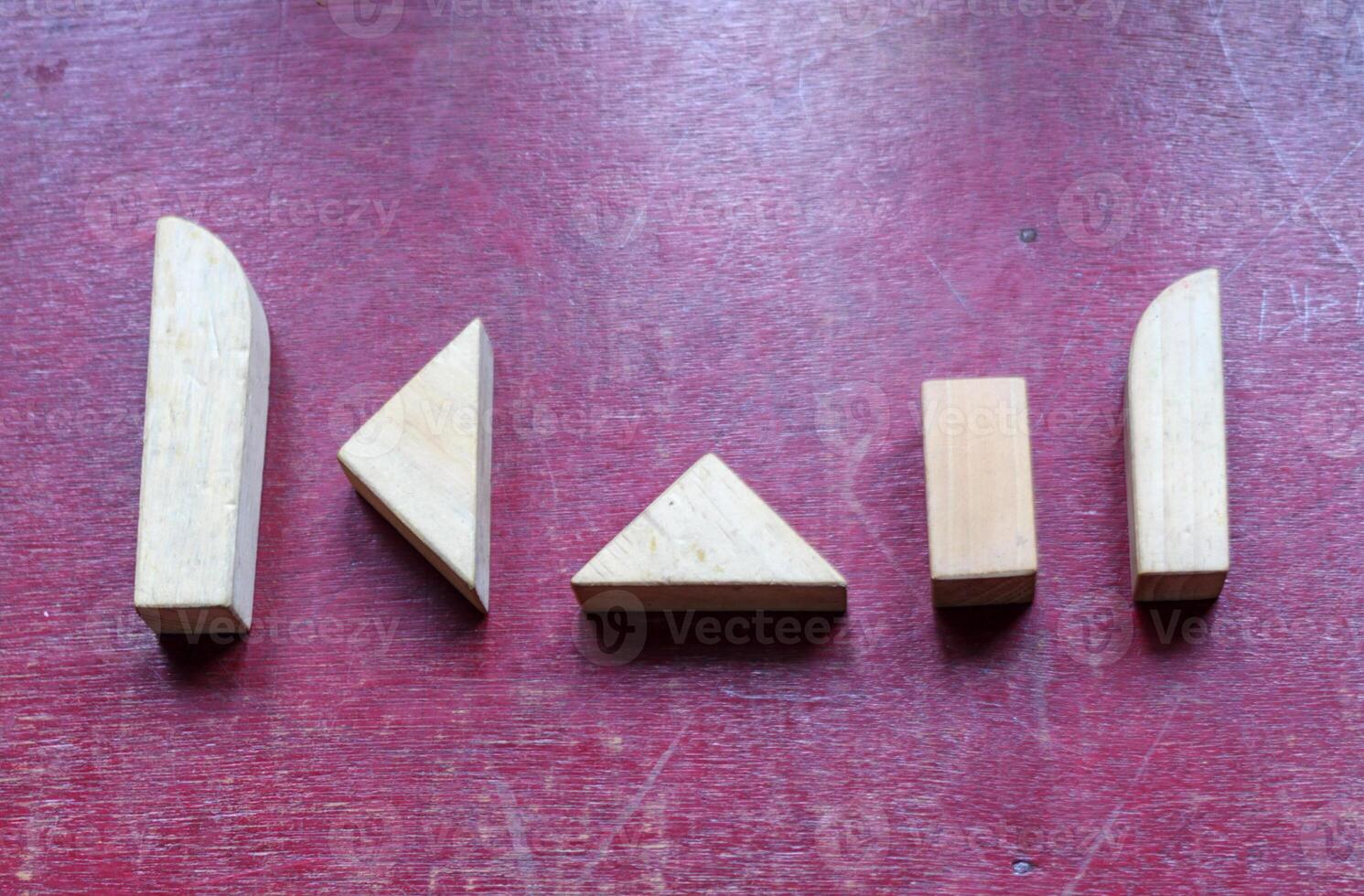 Geometric Wooden Blocks on a Textured Red Surface photo