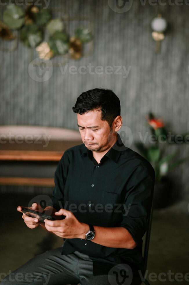 Absorbed man using cellphone indoors with muted background design photo