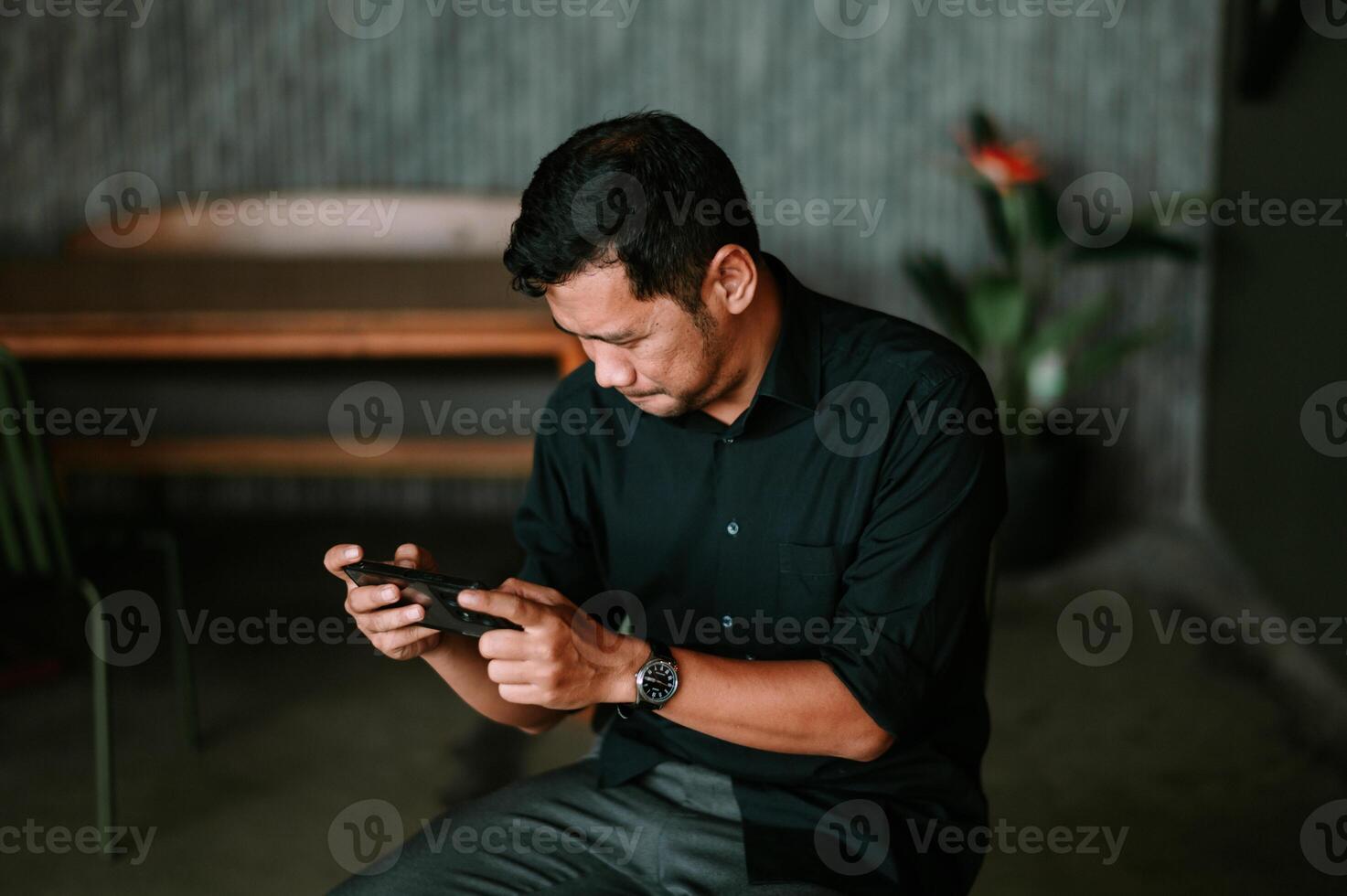 Engrossed man interacts with his mobile device at relaxing lounge setting photo