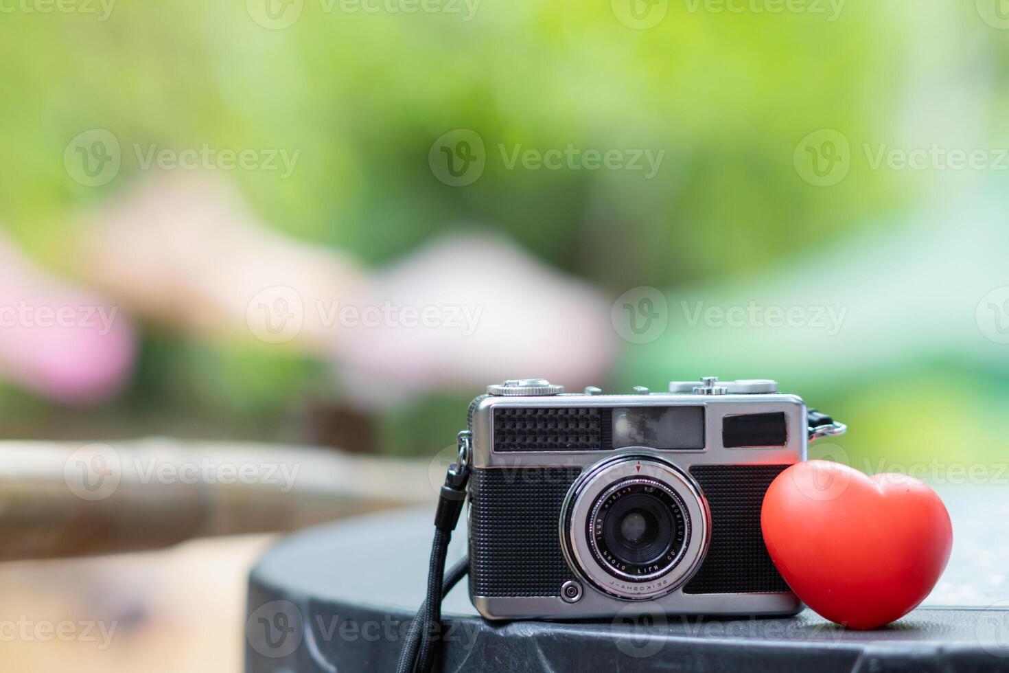 cameras and red heart symbol are placed on photographer desk to symbolize the love of photography and the unique tone of the film camera. Some photographers are still in love with film cameras. photo